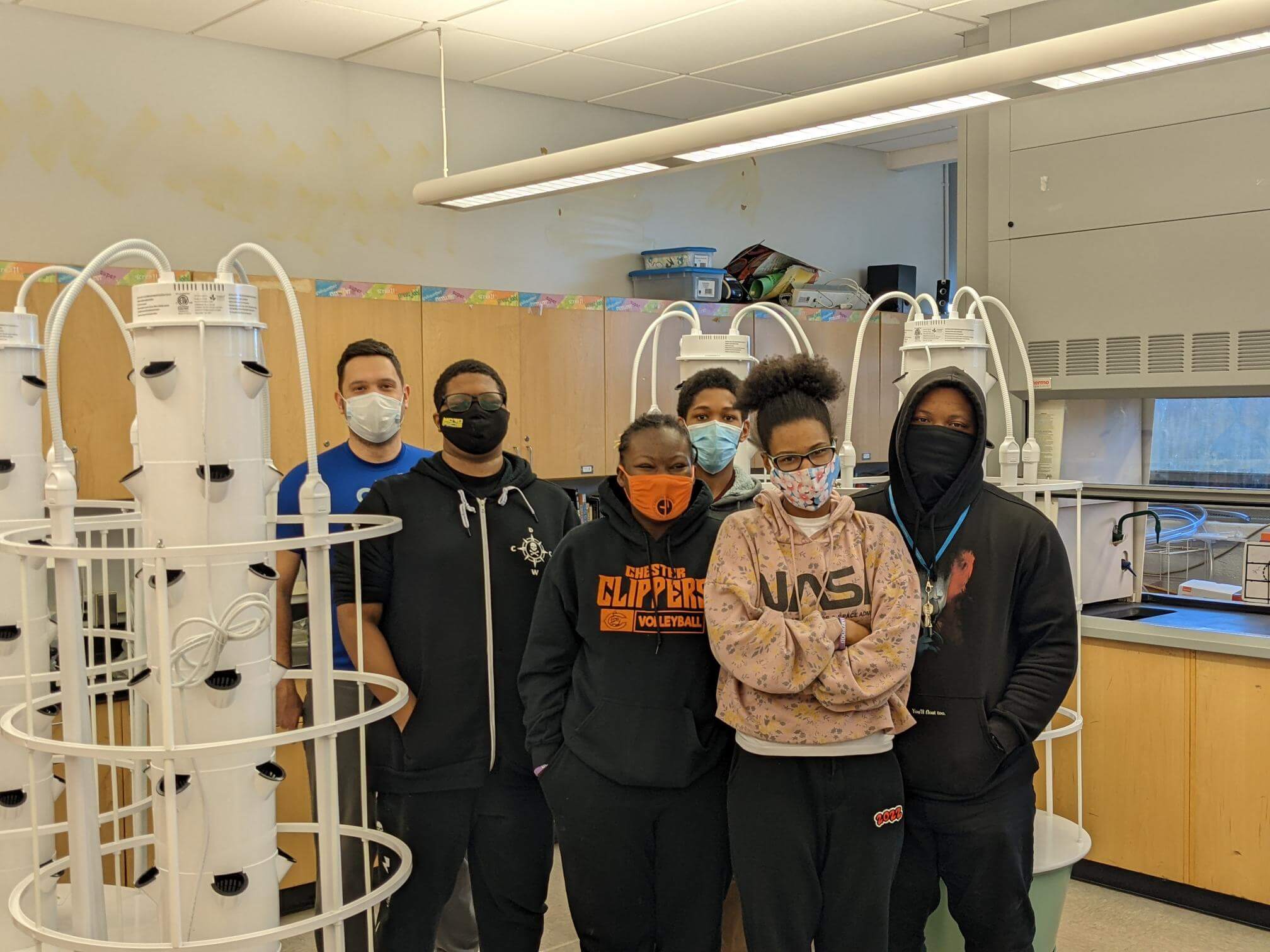Stem Academy Local Leaders standing next to their 4 newly built tower gardens, along with their faculty advisor Mr. Piasecki. Pictured: Rachelle, Marima, Kam'ren, Desean, Deshawn, and Mr. Piasecki