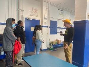 Mr. Ritz showing our Local Leaders around the gym turned cafeteria and where he sets up his salad bar everyday.
